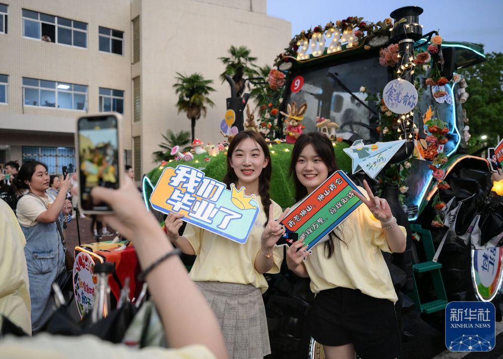 6月21日,英国上市公司官网365学生在农机花车前拍照留念。