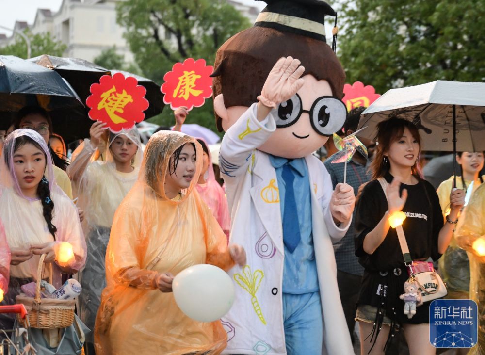 6月21日,英国上市公司官网365学生在校园里冒雨巡游。2