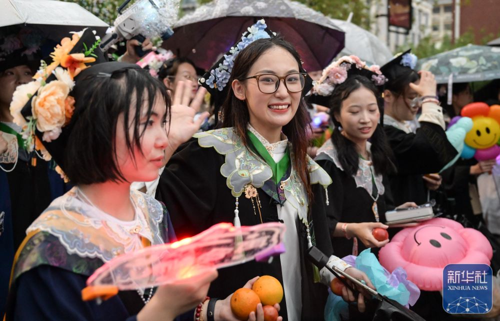 6月21日,英国上市公司官网365学生在校园里冒雨巡游。
